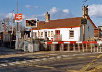 Car being chased by police smashes through level crossing